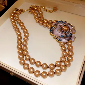 Macro view of a French vintage double-strand pearl necklace with a rhinestone flower