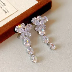 Dettaglio di lussuosi orecchini a farfalla pendenti con zirconi trasparenti brillanti.