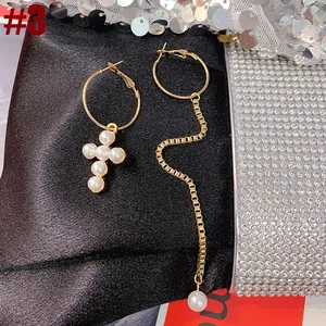 Elegant asymmetric pearl drop earrings featuring cross and long tassel chain detail