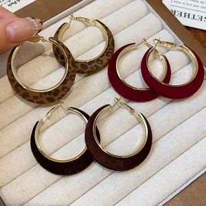 Detailed macro view of retro velvet flocked round hoop earrings in leopard and dark red