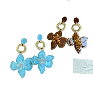 Bohemian style resin flower drop earrings with gold-toned hammered rings and crystal centers