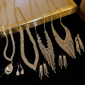 Detailed view of gold-tone fringe necklaces and waterdrop earrings with shiny rhinestones