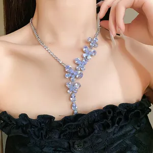 Primo piano di un'elegante collana di zirconi con farfalla e fiore su pizzo nero