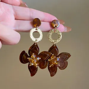 Detailed view of brown marbled resin flower earrings with amber crystal centers.