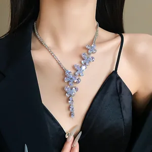 Dettaglio di un'elegante collana in argento con fiori a farfalla e zirconi a goccia d'acqua