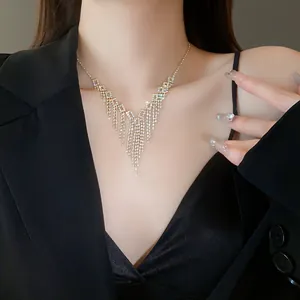 Close-up of a sparkly rhinestone tassel fringe necklace on a female model wearing black