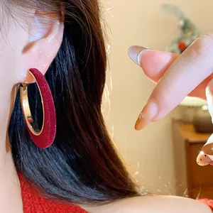 Close-up detail of elegant red flocked hoop earrings with premium velvet texture