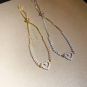 Close-up of elegant gold and silver heart bracelets with zircon stones and bolo clasp