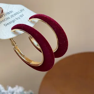 Macro view of burgundy flocked gold-tone hoop earrings with S925 silver needle