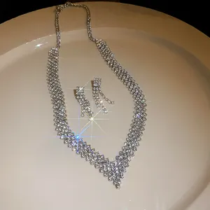 Detailed close-up view of an elegant V-shaped silver rhinestone necklace and earrings set