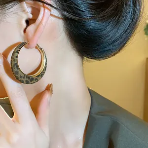 Close-up of stylish leopard print flocked hoop earring with golden metal inner rim