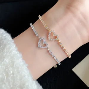 Detailed macro view of elegant silver and gold heart zircon tennis bracelets on a wrist