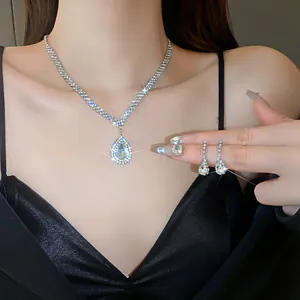 Close-up of sparkling water drop crystal necklace and matching earrings on a model