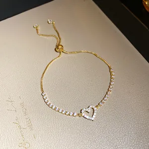 Premium detail of a gold-toned adjustable heart tennis bracelet with shimmering zircon stones
