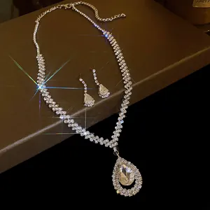 Detailed view of rhinestone waterdrop necklace and earrings set with sparkle effect