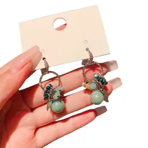 Bohemian gold-tone zircon and green stone dangle earrings with geometric bead charms
