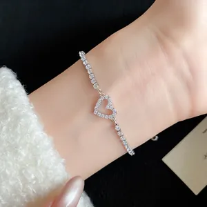 Elegant close-up view of a silver heart-shaped zircon bracelet worn on a female wrist