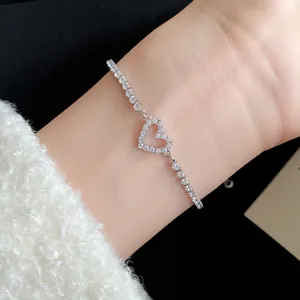 Detail view of sparkling zircon heart bracelet on wrist with elegant fuzzy sleeve