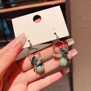 Detail view of Bohemian zircon and glass bead geometric drop earrings on display card