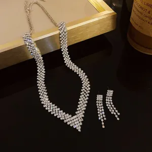 Close-up view of a V-shaped geometric necklace and earrings set with sparkling rhinestones