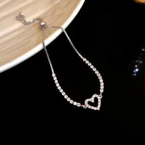 Detail view of silver heart pendant bracelet with sparkling zircon tennis chain