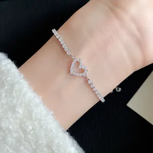 Close-up of elegant silver zircon heart bracelet on wrist with cozy white sweater