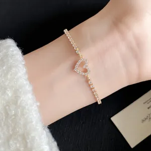 Close-up of gold-plated bracelet featuring a heart pendant set with sparkling cubic zirconia