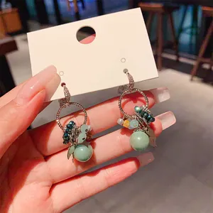 Detailed view of Bohemian geometric earrings with zircon and mint green beads