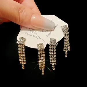 Elegant sparkling rhinestone tassel earrings displayed on a white presentation card.