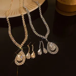 Close-up of sparkling teardrop necklace and earring sets in gold and silver finish