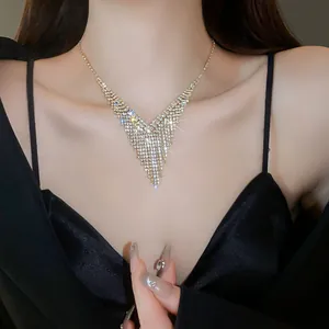 Close-up of a sparkling V-shaped rhinestone fringe necklace on a model's neck.