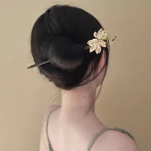 Elegant flower hair stick with butterfly details shown in a classic updo bun style.