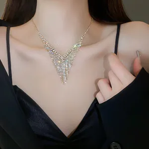 Close-up view of an elegant gold-tone V-shaped rhinestone tassel necklace worn by a model