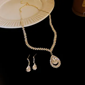 Elegant rhinestone water-drop necklace and matching earrings set on black surface