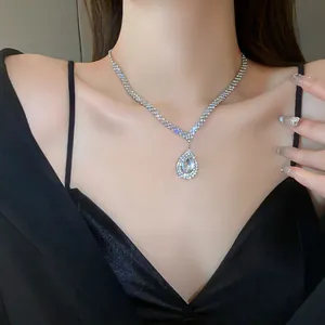 Elegant teardrop rhinestone pendant necklace on model in black dress