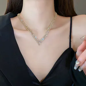 Detailed close-up showing a sparkling gold-tone V-shaped rhinestone necklace on a model.