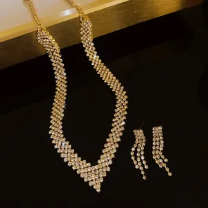Detailed view of gold rhinestone necklace and earring set on black reflective surface