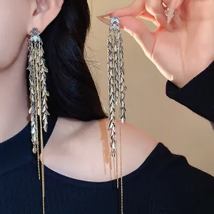 Detailaufnahme eleganter langer silberner Quastenohrringe mit Blattmotiven an einem Model