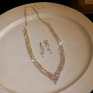 Close-up of sparkling rhinestone geometric necklace and earring set on ceramic plate