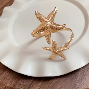 Macro view of gold metal starfish arm ring featuring realistic sea star texture detail