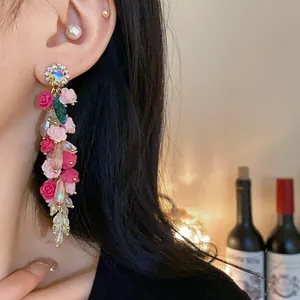 Close-up of elegant floral tassel earrings with colorful crystals and resin flowers.