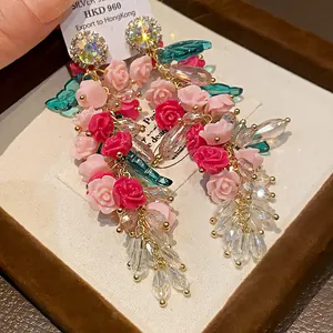 Detailed macro view of heavy-duty crystal tassel earrings with pink and red roses.