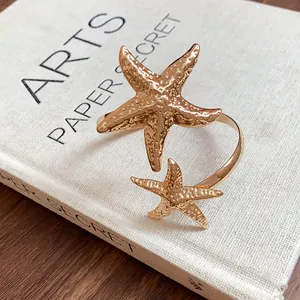 Macro view of gold starfish armlet showing detailed metallic texture on white book