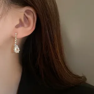 Detailed close-up showing a sparkling rhinestone waterdrop dangling earring on model ear