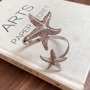 Close-up detail of a silver starfish arm cuff bracelet featuring a textured metal finish