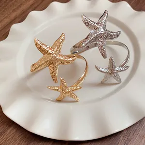 Close-up detail of irregular metal starfish arm cuffs in gold and silver finishes
