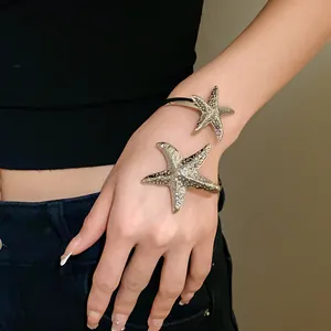 Detailed close-up shot of an irregular silver starfish armlet with textured metal surface.