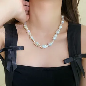 Detailed close-up of irregular baroque pearl necklace worn on model for minimalist look
