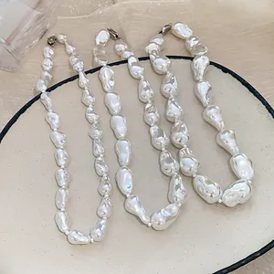 Detailed view of three irregular baroque pearl necklaces displayed on a chic ceramic plate