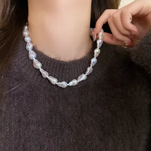 Irregular baroque pearl necklace choker shown on model wearing dark brown sweater